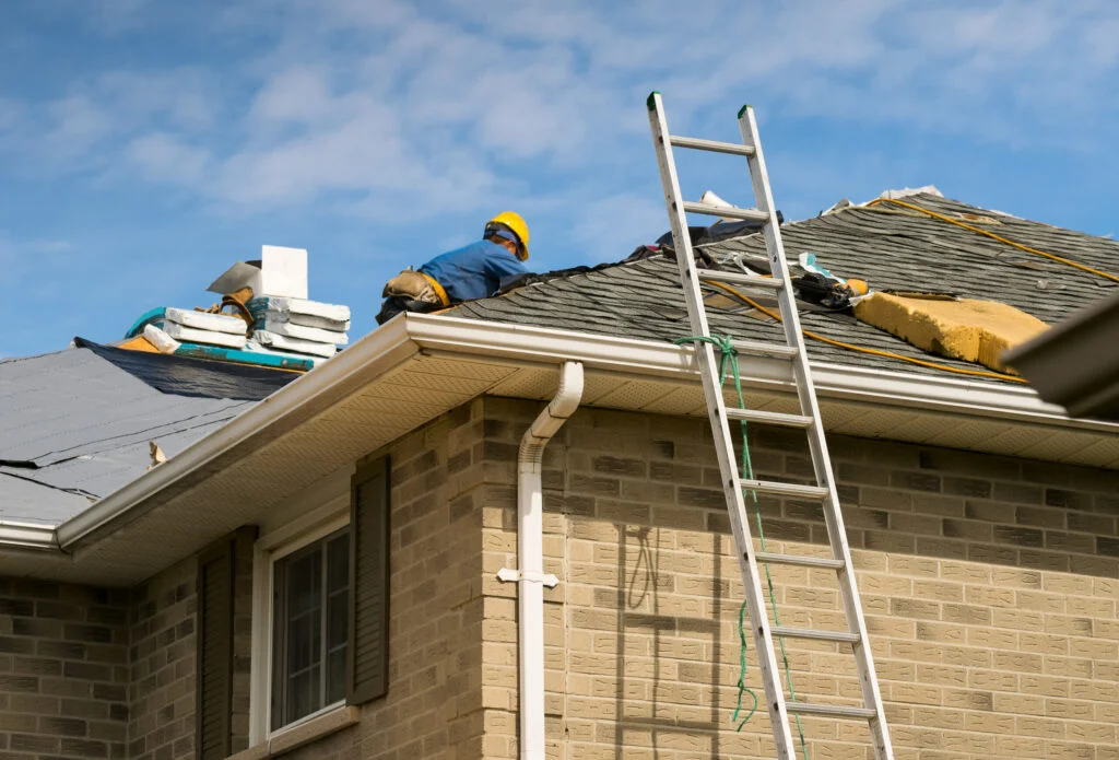 how to shingle a roof - Roof worker installing new shingles on a roof of a house