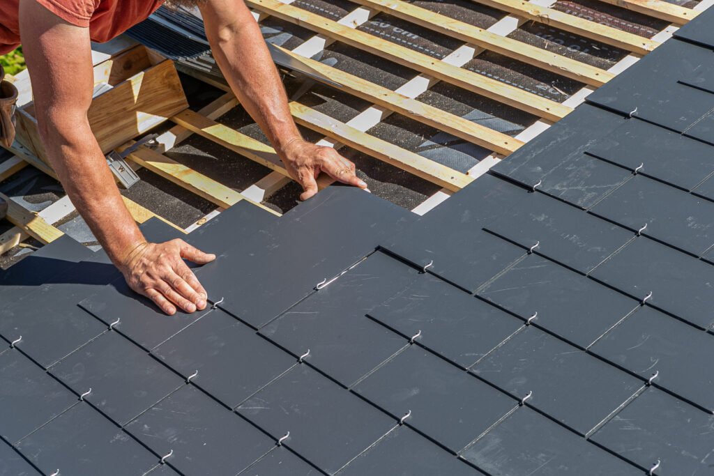 How Long Does A Roof Last - Craftsmen are installing a slate roof home.Professional roof workers repairing roof t.Working on rooftop.